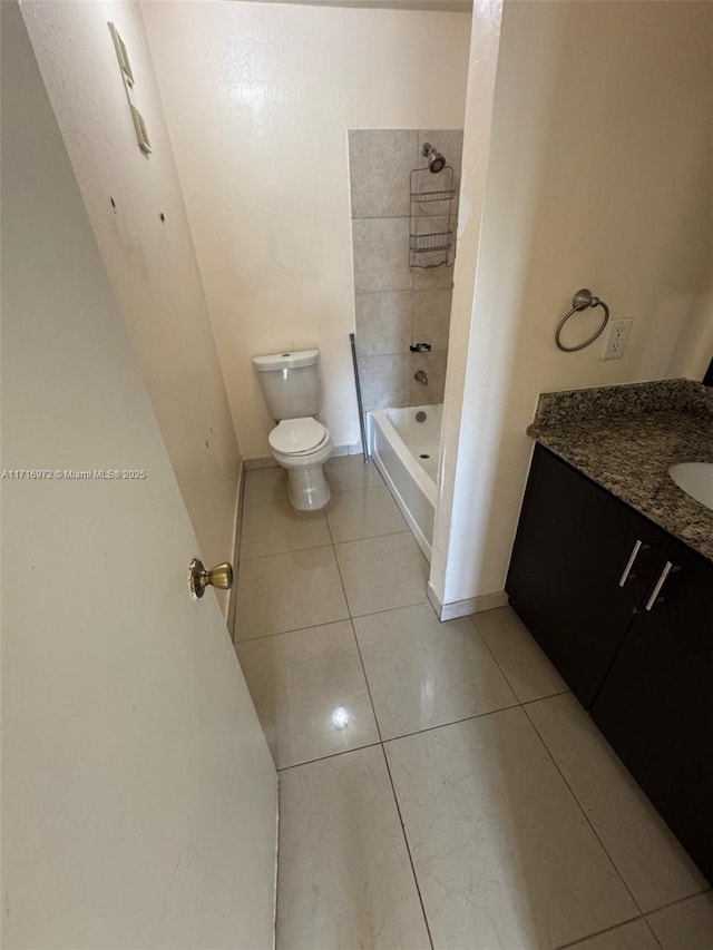 full bathroom featuring tile patterned flooring, vanity, toilet, and tiled shower / bath combo