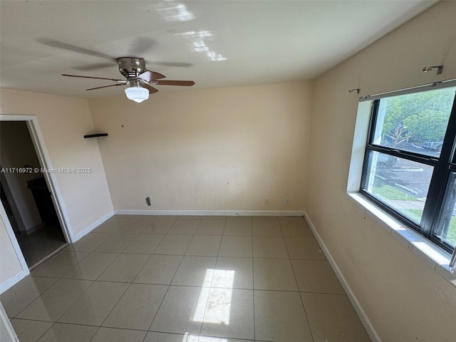 empty room with ceiling fan and light tile patterned flooring