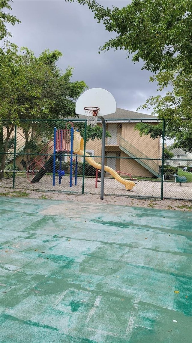 view of basketball court featuring a playground