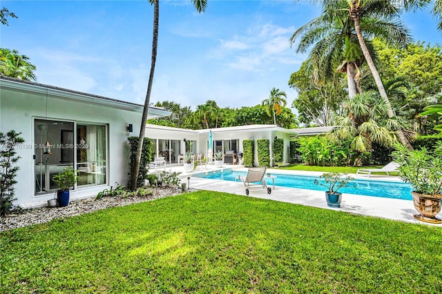 view of pool with a patio area and a yard