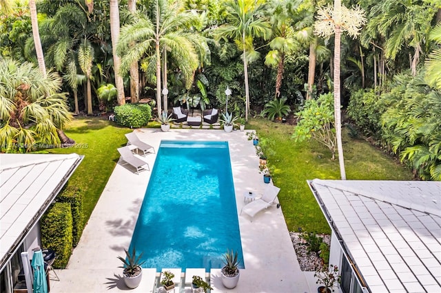 view of pool with a lawn and a patio area