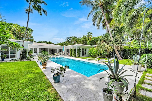 view of pool featuring a lawn