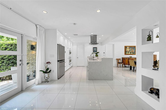 kitchen featuring a wealth of natural light, white cabinetry, sink, and light stone countertops