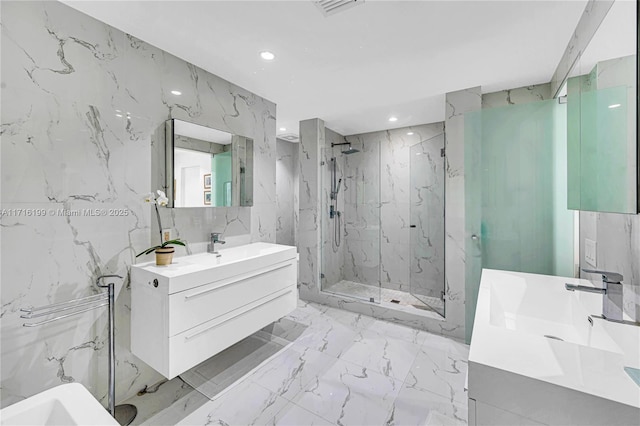 bathroom with vanity, a shower with door, and tile walls