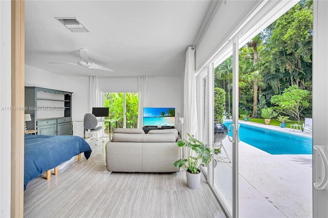 bedroom featuring access to exterior, ceiling fan, and multiple windows