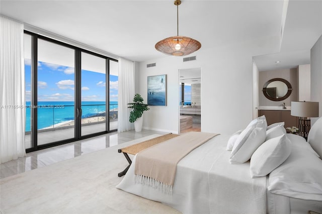 bedroom featuring access to outside, expansive windows, a water view, a view of the beach, and ensuite bath