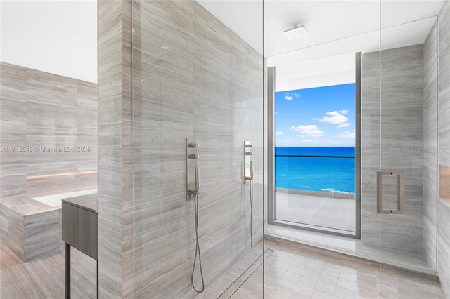 bathroom featuring tile patterned flooring, a water view, and walk in shower