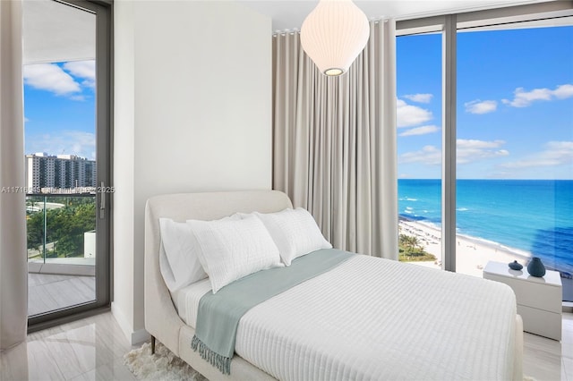 bedroom featuring a beach view, access to outside, a water view, and expansive windows