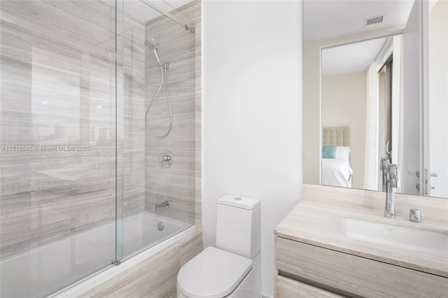 full bathroom featuring vanity, toilet, and bath / shower combo with glass door