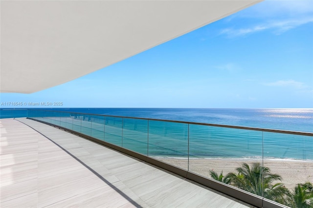 balcony featuring a beach view and a water view