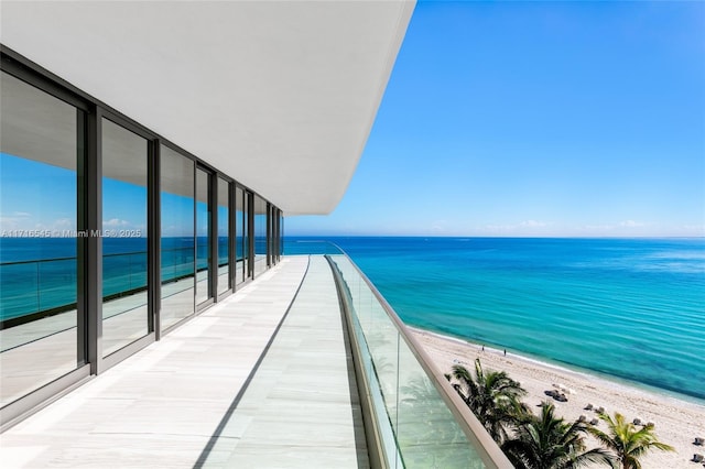 balcony featuring a beach view and a water view