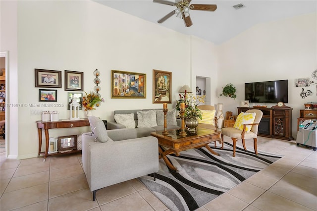 living area featuring light tile patterned floors, visible vents, and a towering ceiling