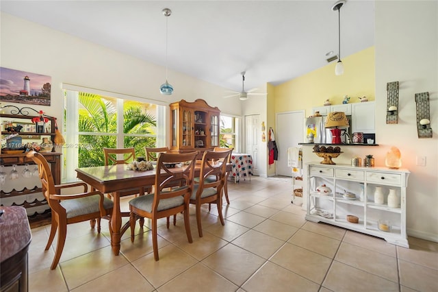 dining space with ceiling fan, light tile patterned floors, and high vaulted ceiling