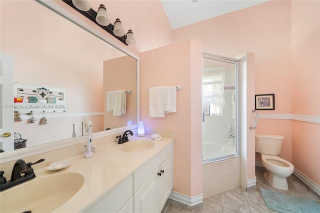 bathroom with a sink, toilet, shower / bath combination with glass door, and double vanity