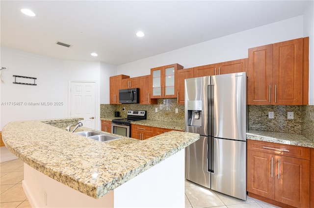 kitchen with a center island with sink, decorative backsplash, light tile patterned flooring, and stainless steel appliances