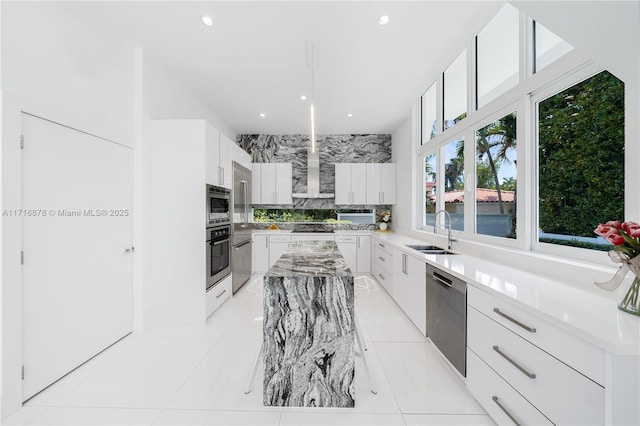 kitchen featuring appliances with stainless steel finishes, backsplash, sink, white cabinetry, and light tile patterned flooring