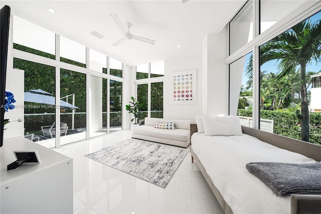 bedroom with floor to ceiling windows, tile patterned flooring, ceiling fan, access to exterior, and multiple windows