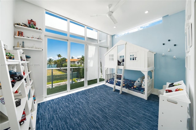 carpeted bedroom featuring ceiling fan, expansive windows, access to exterior, and multiple windows