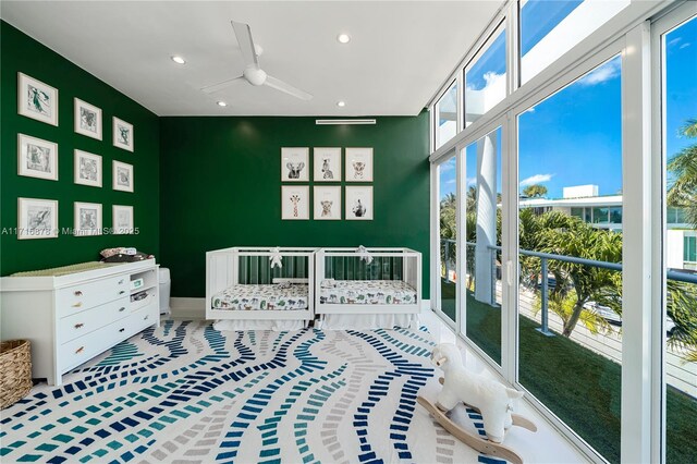 interior space with ceiling fan and a crib