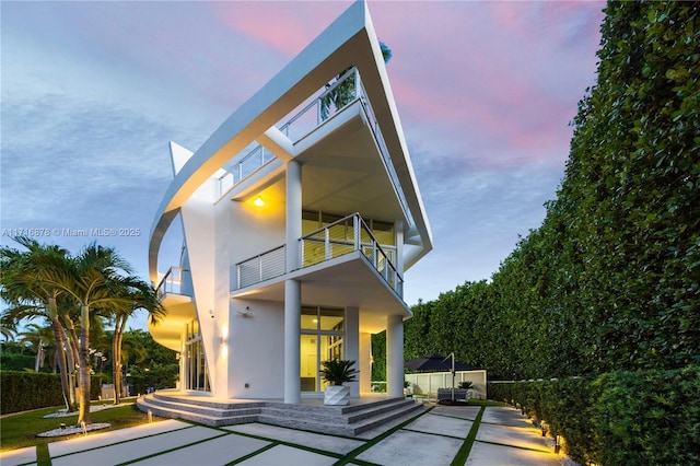 back house at dusk with a balcony