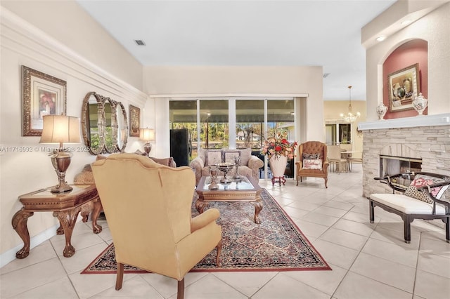 living room with a fireplace, light tile patterned flooring, and an inviting chandelier