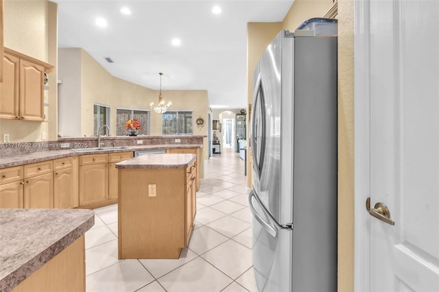 kitchen featuring a center island, stainless steel fridge, hanging light fixtures, and light brown cabinetry