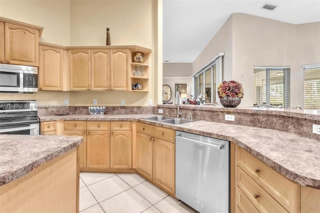 kitchen featuring appliances with stainless steel finishes, light tile patterned floors, light brown cabinetry, and sink