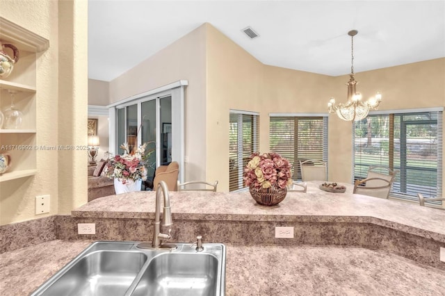 kitchen with a chandelier, pendant lighting, and sink