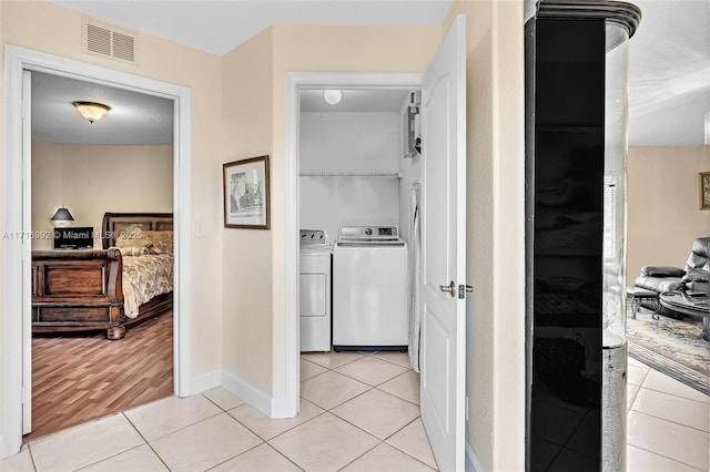 corridor with washer and dryer and light tile patterned flooring