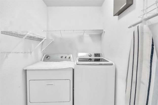 clothes washing area featuring washer and clothes dryer