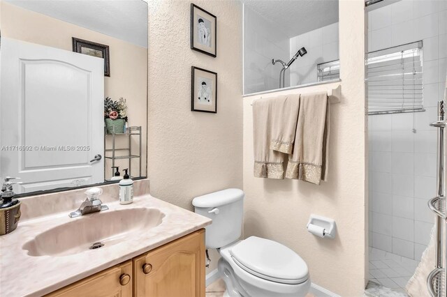 bathroom featuring vanity, toilet, and a tile shower