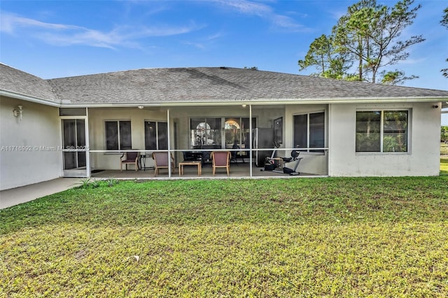 back of house featuring a sunroom, a patio area, and a lawn