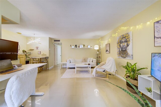 living room featuring a chandelier, a textured ceiling, and light tile patterned flooring