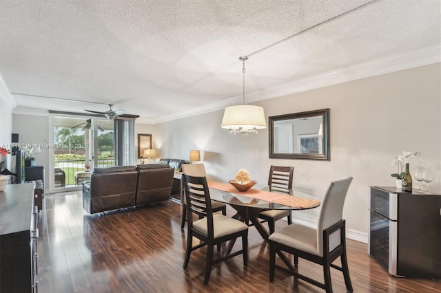 dining area featuring dark hardwood / wood-style flooring, a textured ceiling, ornamental molding, and ceiling fan