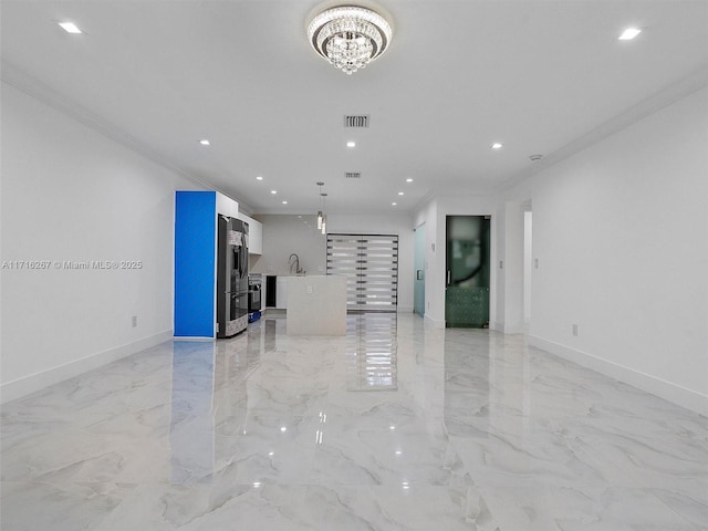 unfurnished living room with ornamental molding, sink, and a chandelier