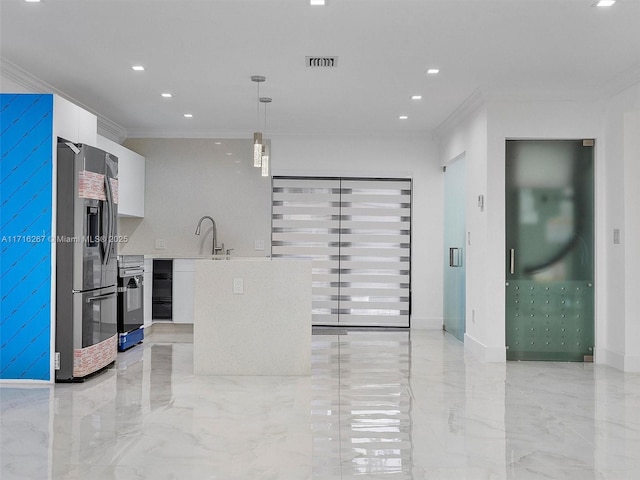 kitchen featuring white cabinets, sink, crown molding, stainless steel fridge, and decorative light fixtures