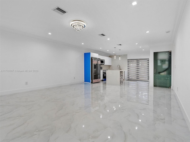 unfurnished living room featuring sink and crown molding