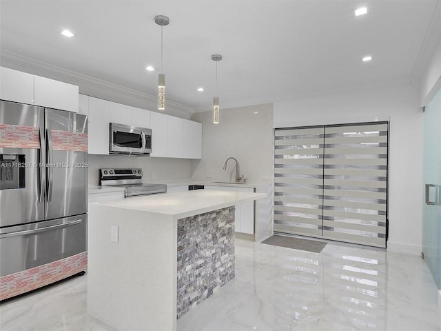 kitchen featuring sink, stainless steel appliances, white cabinets, pendant lighting, and a kitchen island