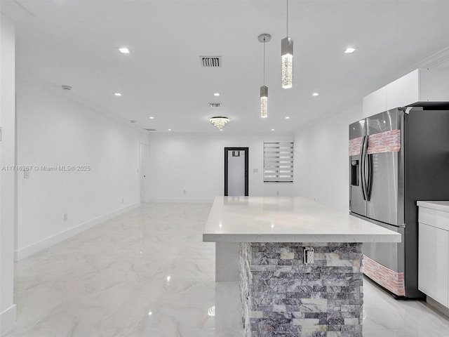 kitchen with white cabinetry, stainless steel fridge, a center island, and hanging light fixtures