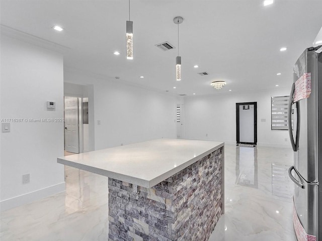 kitchen featuring stainless steel refrigerator, a center island, and hanging light fixtures