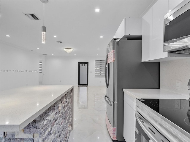 kitchen featuring tasteful backsplash, light stone counters, stove, pendant lighting, and white cabinets