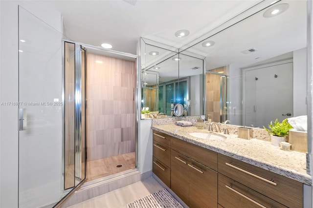 bathroom featuring tile patterned flooring, vanity, and a shower with shower door