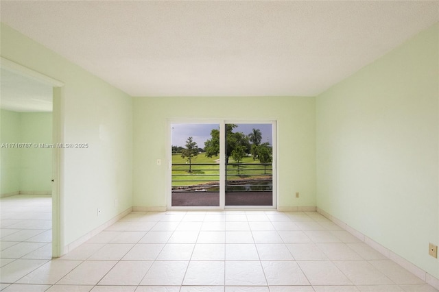 tiled empty room featuring a textured ceiling