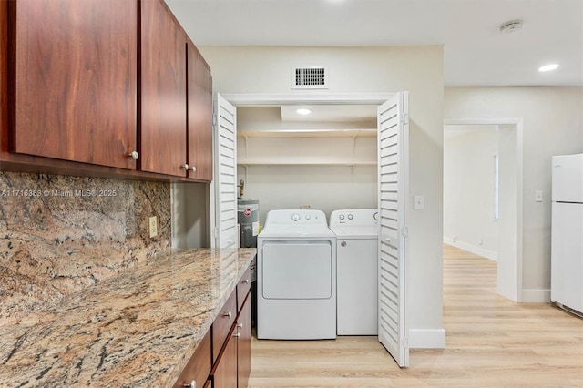 laundry room with light wood-type flooring and washer and clothes dryer