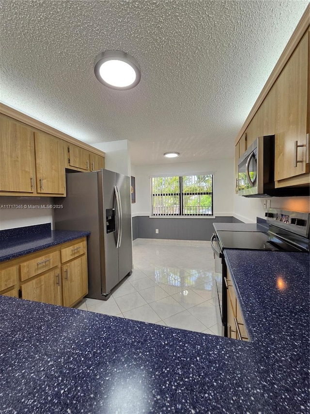 2606 NW 104th Ave Unit 202, Sunrise, FL 33322 - kitchen with appliances with stainless steel finishes, a textured ceiling, light tile patterned floors, and dark countertops