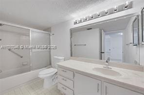 full bathroom with vanity, enclosed tub / shower combo, and toilet