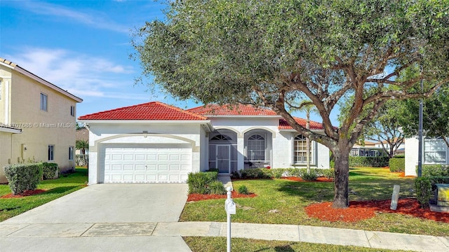 mediterranean / spanish-style house featuring a front yard and a garage