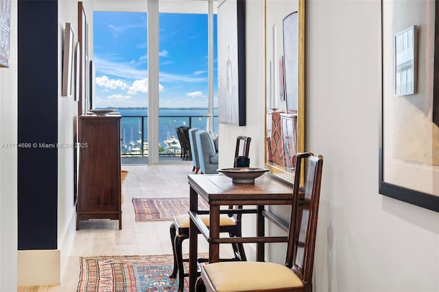 dining space featuring a water view and floor to ceiling windows