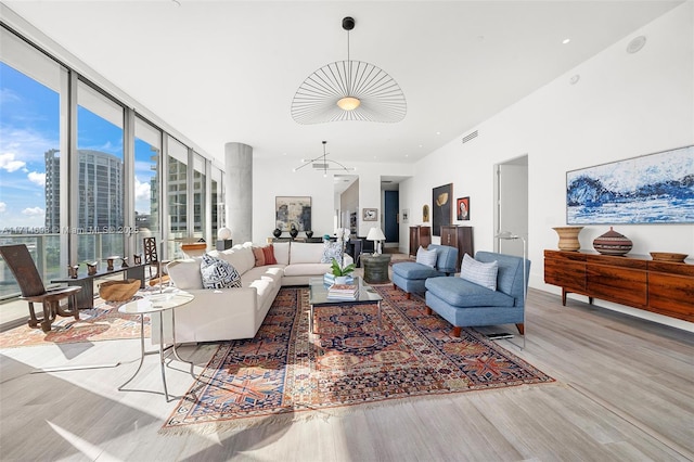 living room with floor to ceiling windows, light hardwood / wood-style flooring, and a notable chandelier