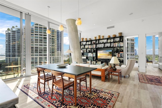 dining space with expansive windows and light hardwood / wood-style floors